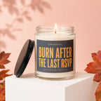 Glass candle with "Burn After The Last RSVP" text, lid off, autumn leaves.
