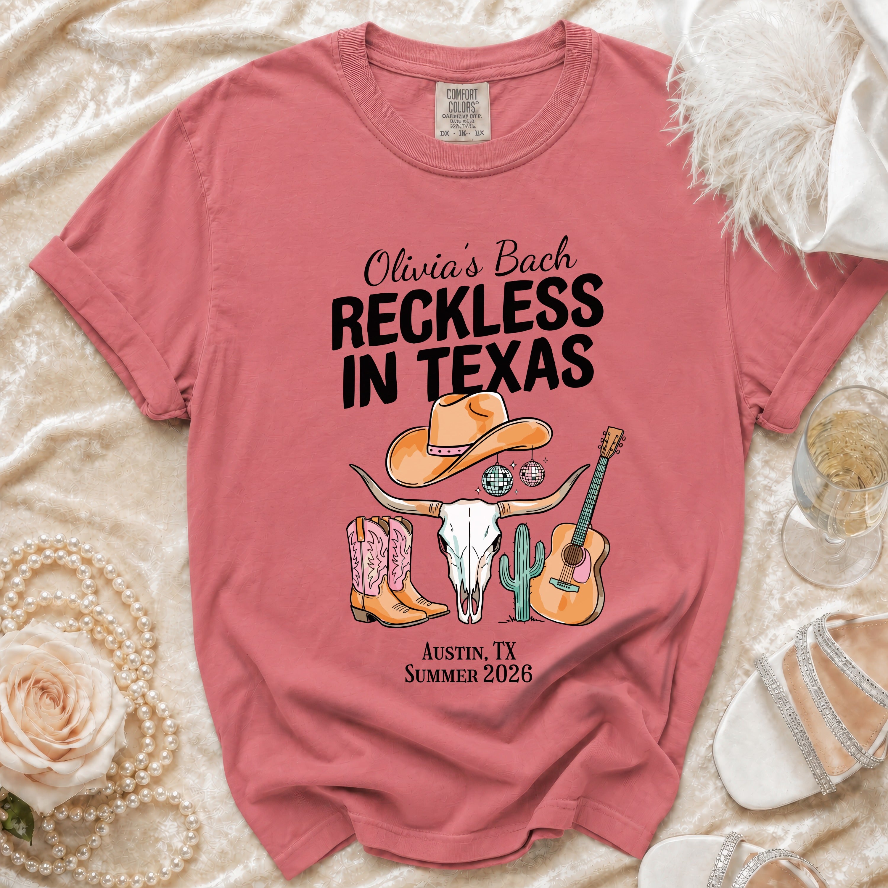T-shirt with "Olivia's Bach Reckless in Texas" text, cow skull, cowboy boots, guitar, disco ball.