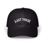 Black baseball cap with white embroidered "LAST TOAST" text on the front.