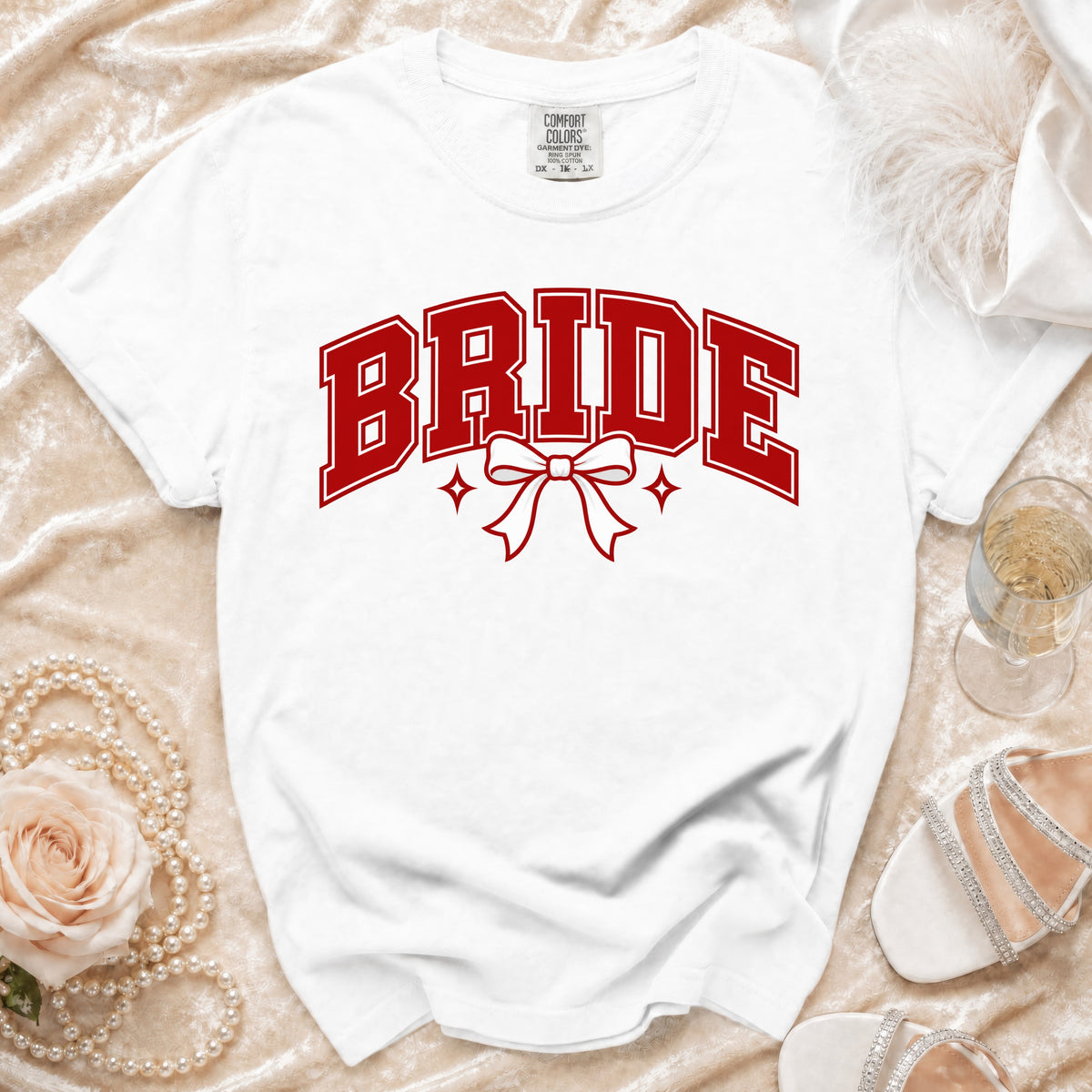 White t-shirt with red "BRIDE" text, bow, and stars graphic.