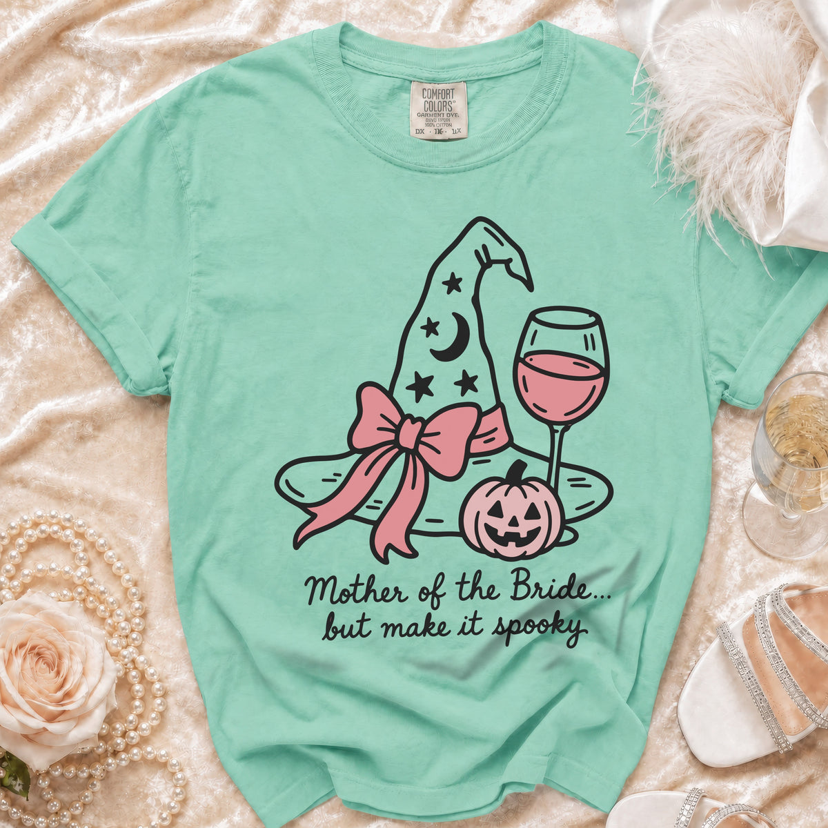 Mint t-shirt with spooky witch hat, pumpkin, and wine glass graphic.