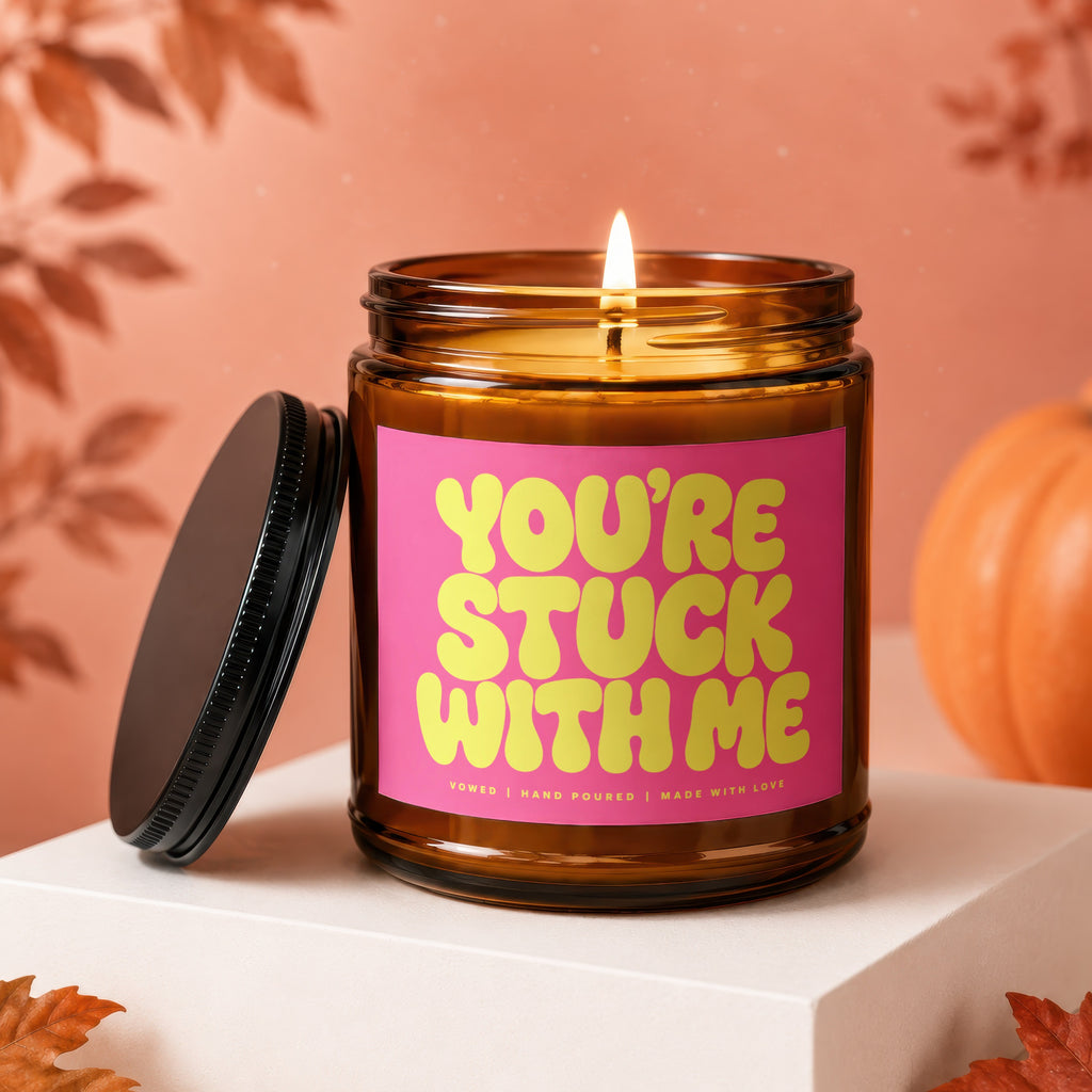 Amber jar candle with pink label reading "YOU'RE STUCK WITH ME"