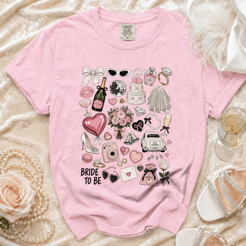 Pink t-shirt with "Bride to Be" and wedding-themed graphics including a cake, champagne, and car.