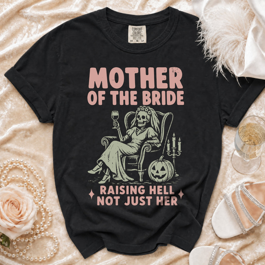 Black t-shirt with "Mother of the Bride Raising Hell Not Just Her" text and skeleton graphic.