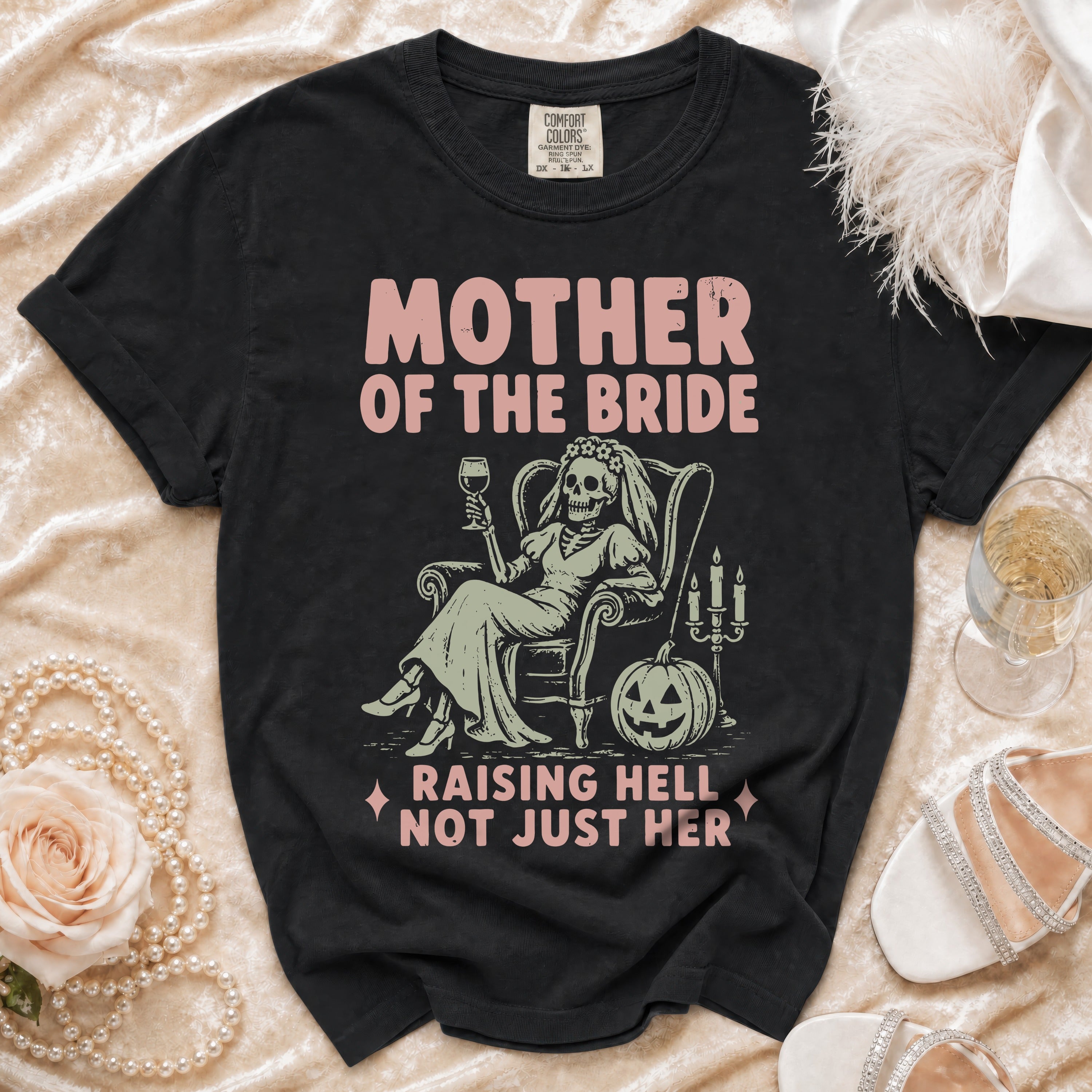 Black t-shirt with "Mother of the Bride Raising Hell Not Just Her" text and skeleton graphic.