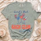 Sage green t-shirt with "Sarah's Bach" and "Bach Club Malibu, Ca Summer 2026" text.
