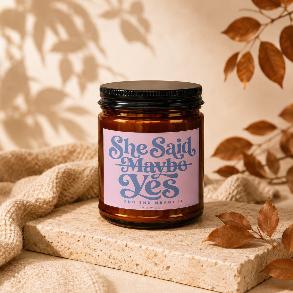 Brown jar candle with pink label reading "She Said Maybe Yes and she meant it VOWED".