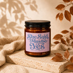 Brown jar candle with pink label reading "She Said Maybe Yes and she meant it VOWED".