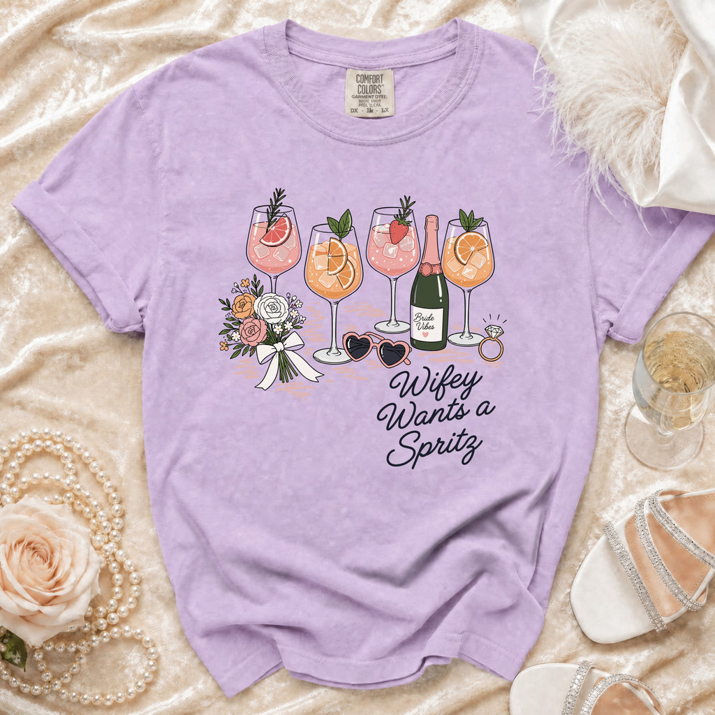 Purple t-shirt with "Wifey Wants a Spritz" graphic and cocktail illustrations.