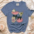 Blue t-shirt with "mother of the bride surviving spooky season" and Halloween graphics.