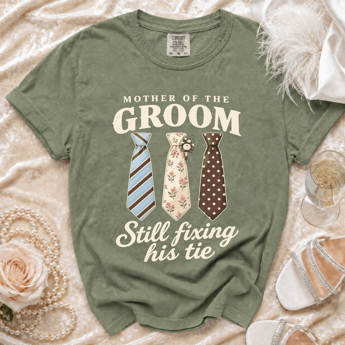 Olive t-shirt with "MOTHER OF THE GROOM Still fixing his tie" text and three ties.