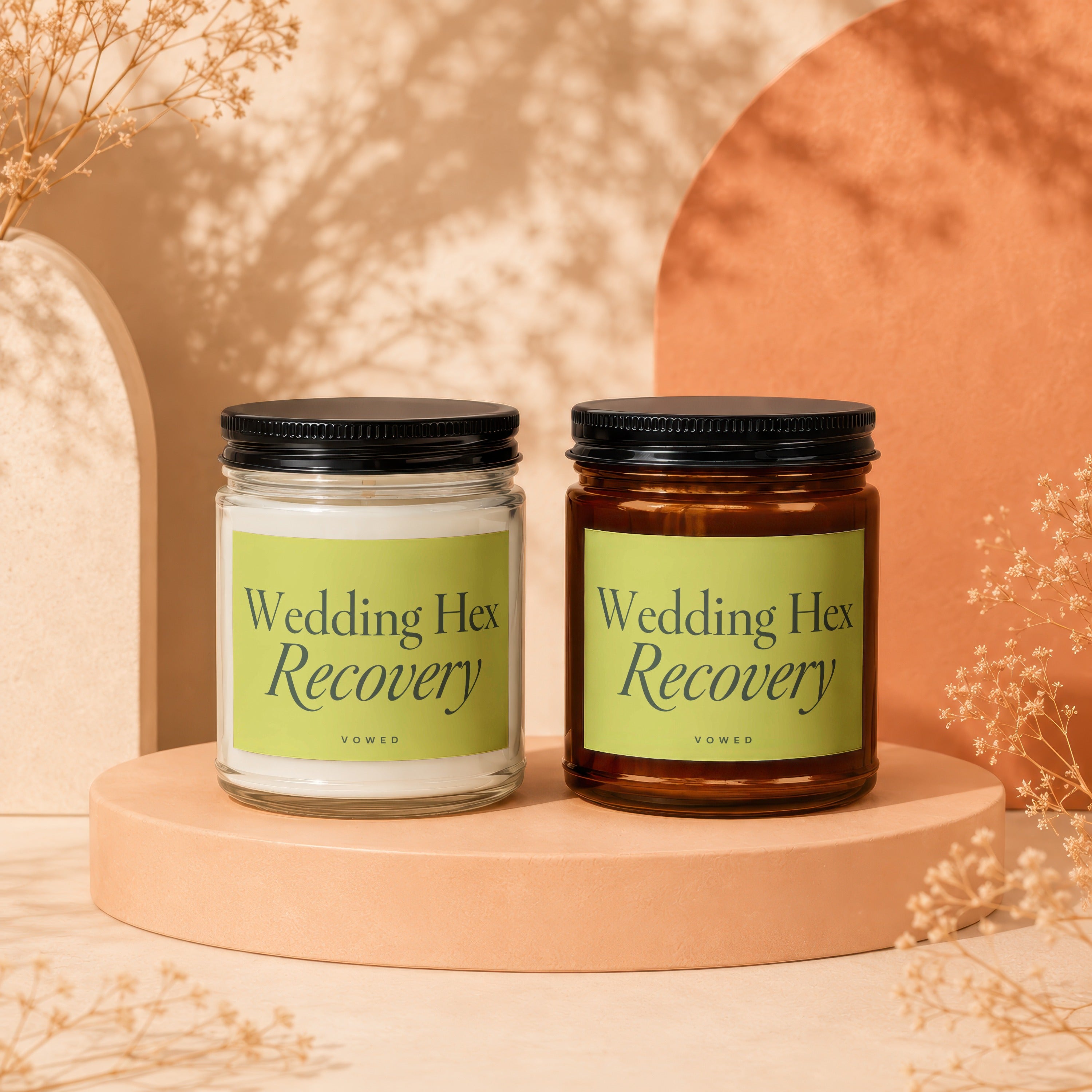 Two candles with black lids labeled "Wedding Hex Recovery" by VOWED.