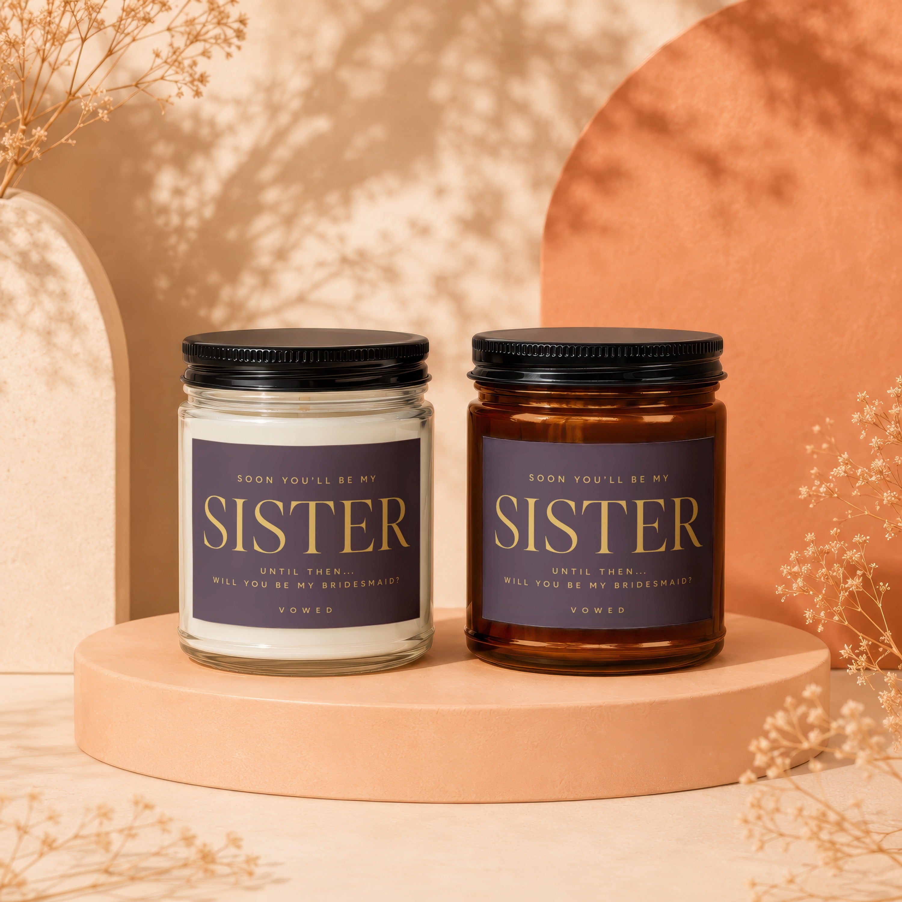 Two "Sister" bridesmaid proposal candles with text and black lids.