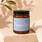 Amber jar candle with light blue label reading "Smells like Future Mrs." and "Vowed".