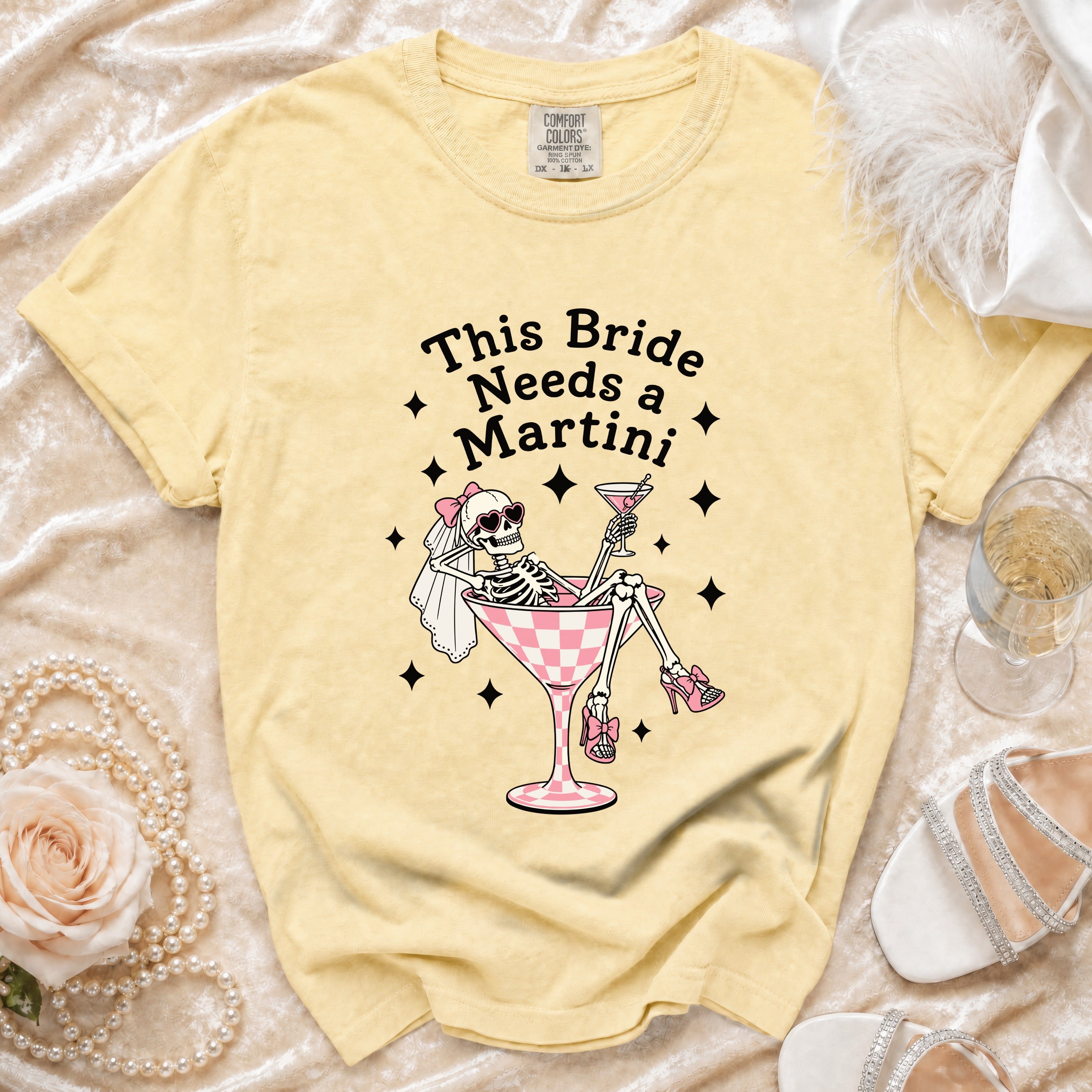 Yellow t-shirt graphic with skeleton bride saying "This Bride Needs a Martini".