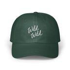 Dark green dad hat featuring white cursive text reading "Wild Wild" centered on the front panels.