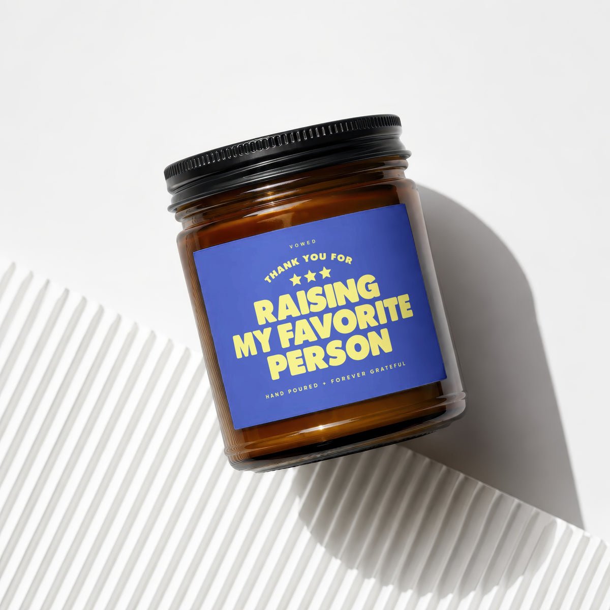 Amber candle in glass jar with blue label reading "Thank You For Raising My Favorite Person".
