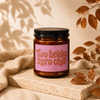 Amber glass candle with pink label reading "Two brides zero chill, VOWED."