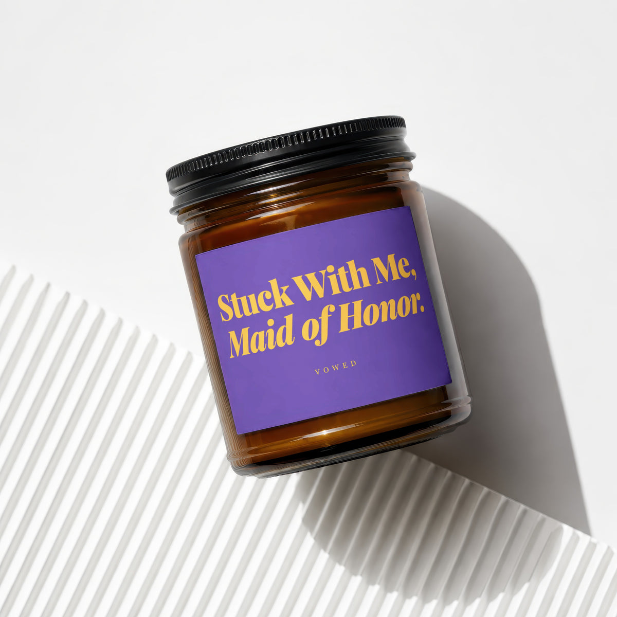 Amber jar candle with purple label reading "Stuck With Me, Maid of Honor."