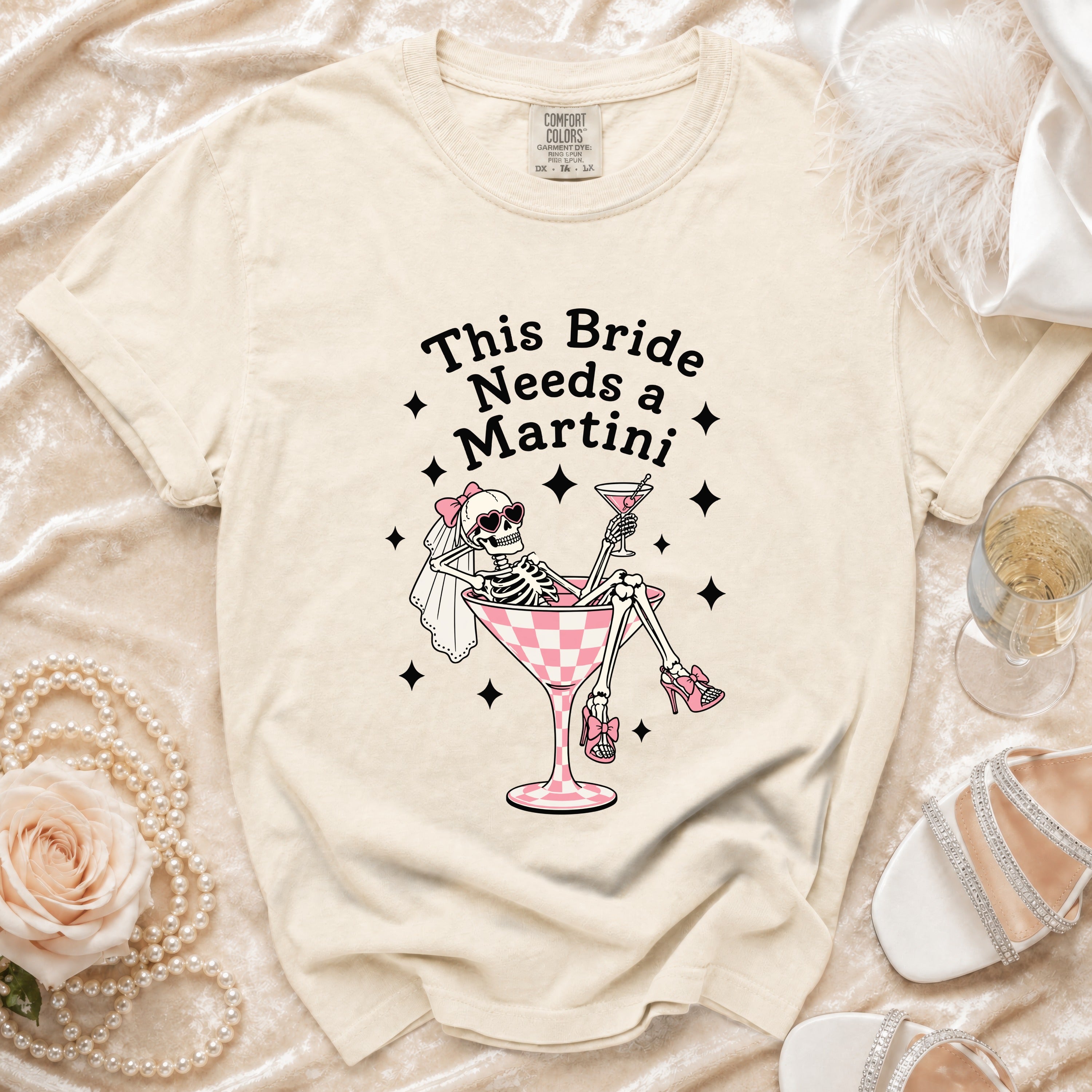 Skeleton bride graphic on a cream t-shirt reading "This Bride Needs a Martini."
