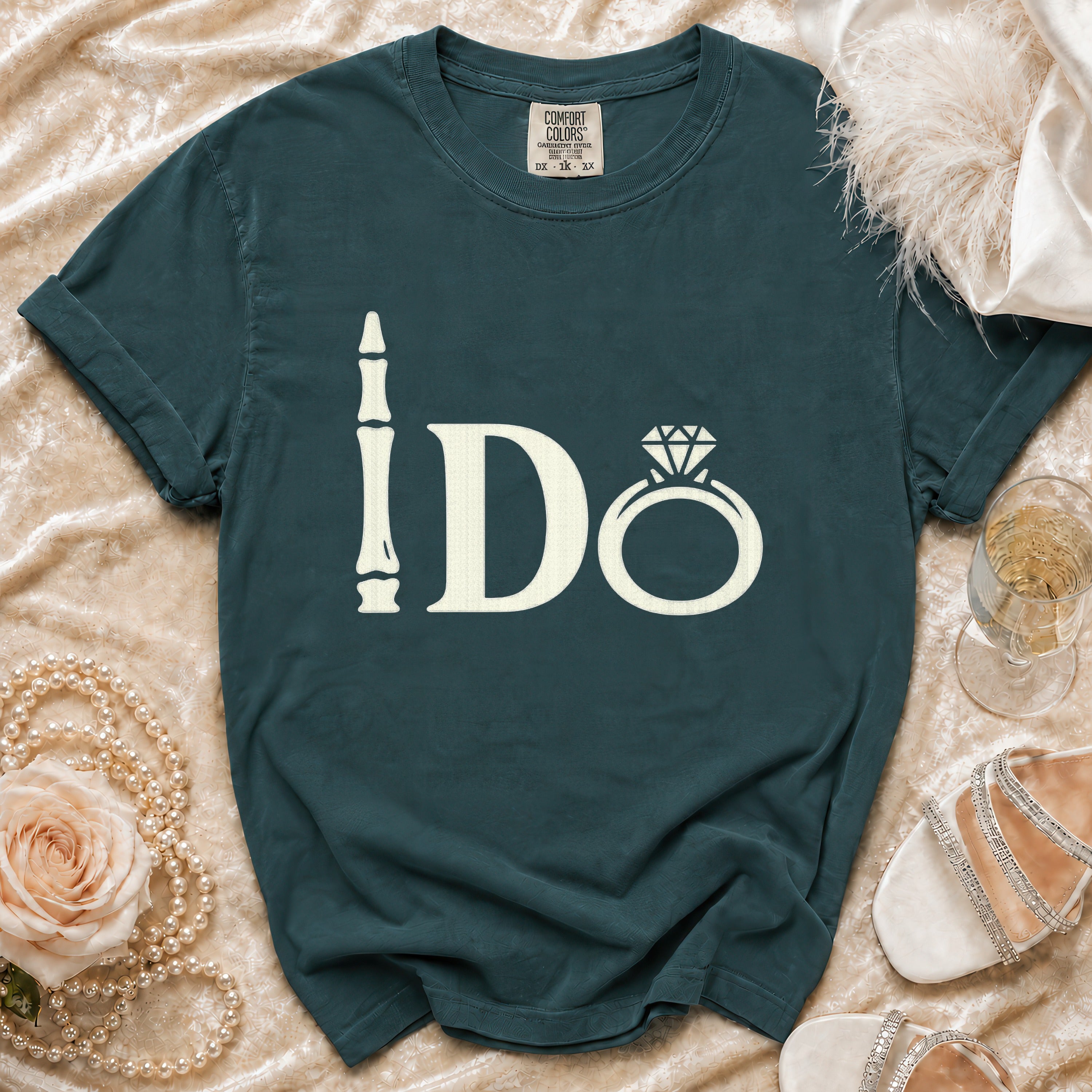 Teal t-shirt with ivory "I Do" text, ring graphic, and tag at neckline.