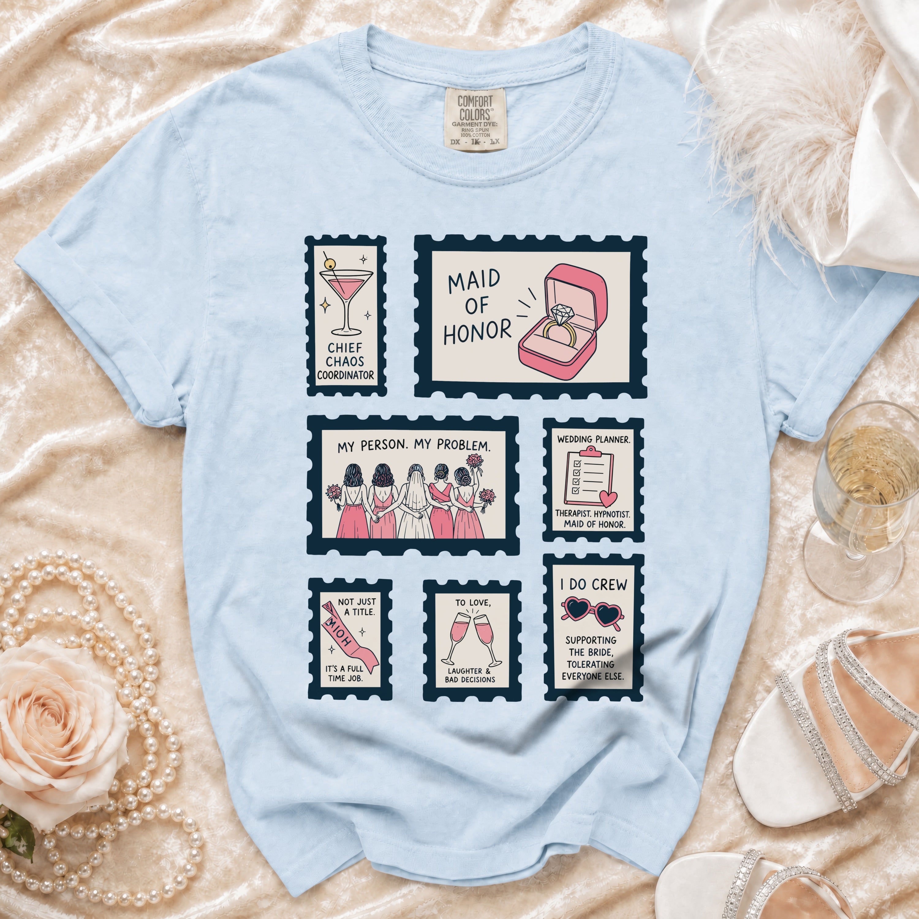 Light blue t-shirt with "Maid of Honor" themes in stamp graphics.