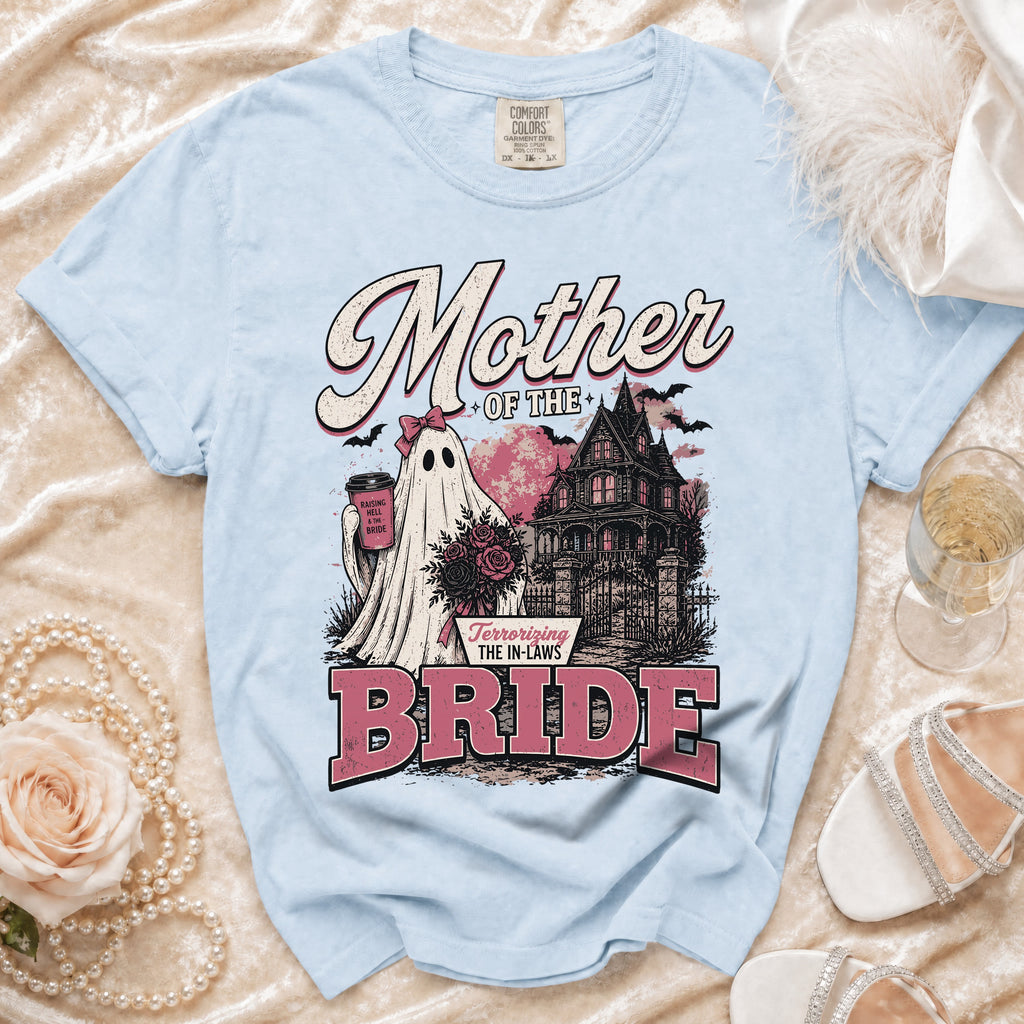 Light blue t-shirt with "Mother of the Bride" text, ghost, haunted house, and roses graphic.