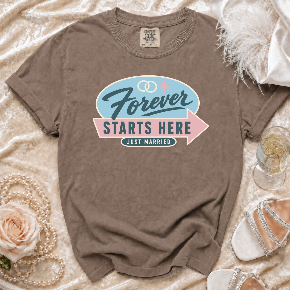 Brown t-shirt with "Forever Starts Here Just Married" graphic and wedding rings.
