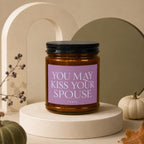 Amber jar candle with purple label reading "YOU MAY KISS YOUR SPOUSE" and "VOWED".