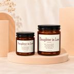 Two brown glass candles labeled "Daughter in Law" with definition text.