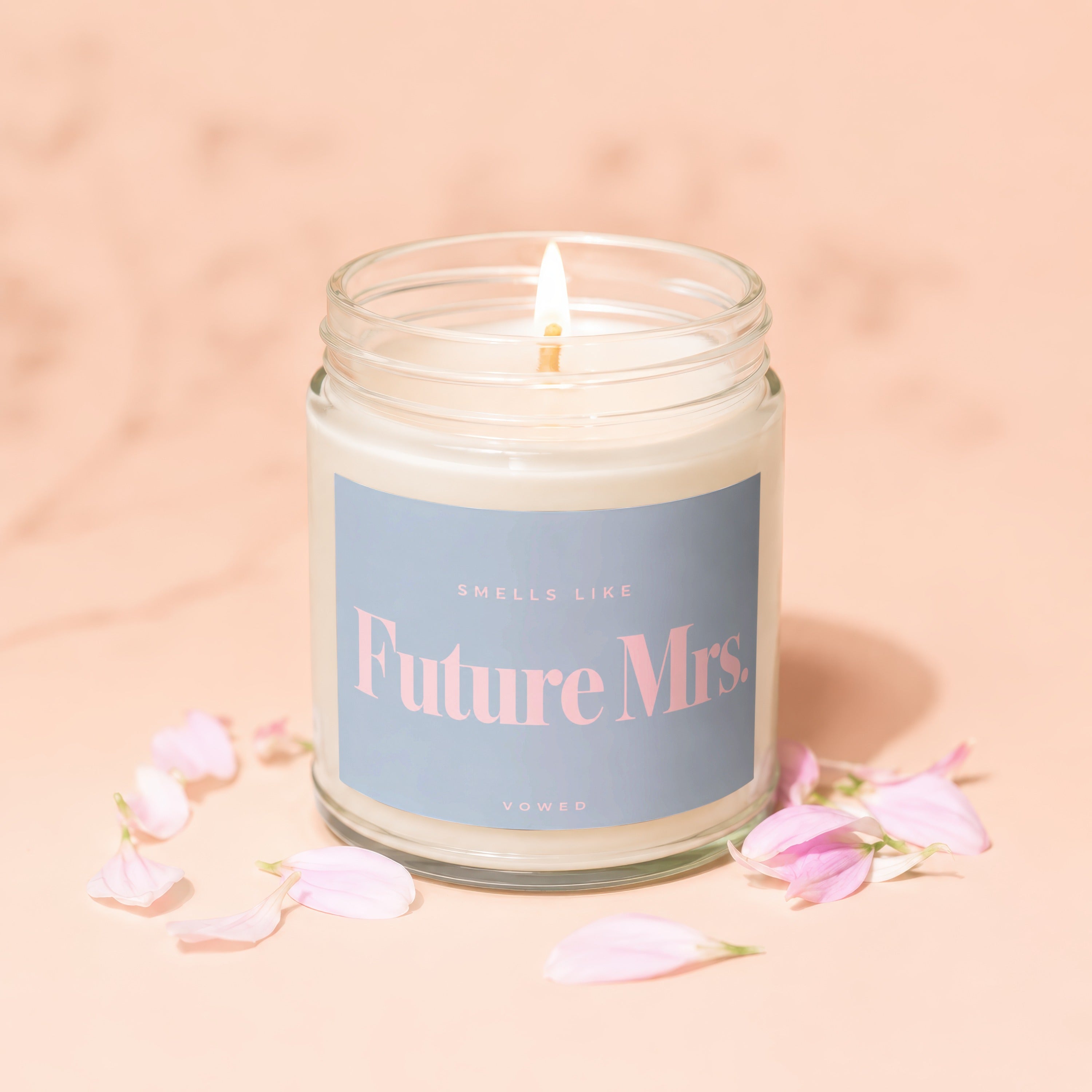 Candle with "Smells Like Future Mrs." text, surrounded by pink petals.