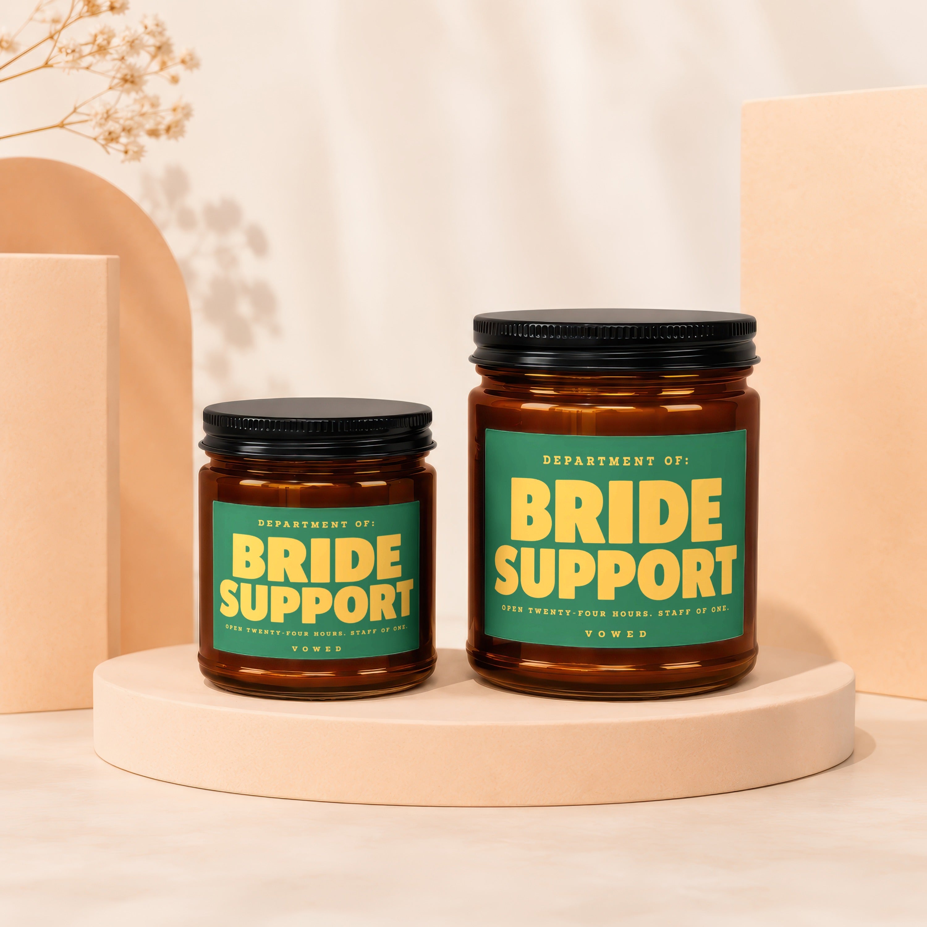 Two brown glass candles labeled "Bride Support" in yellow text on a green label.