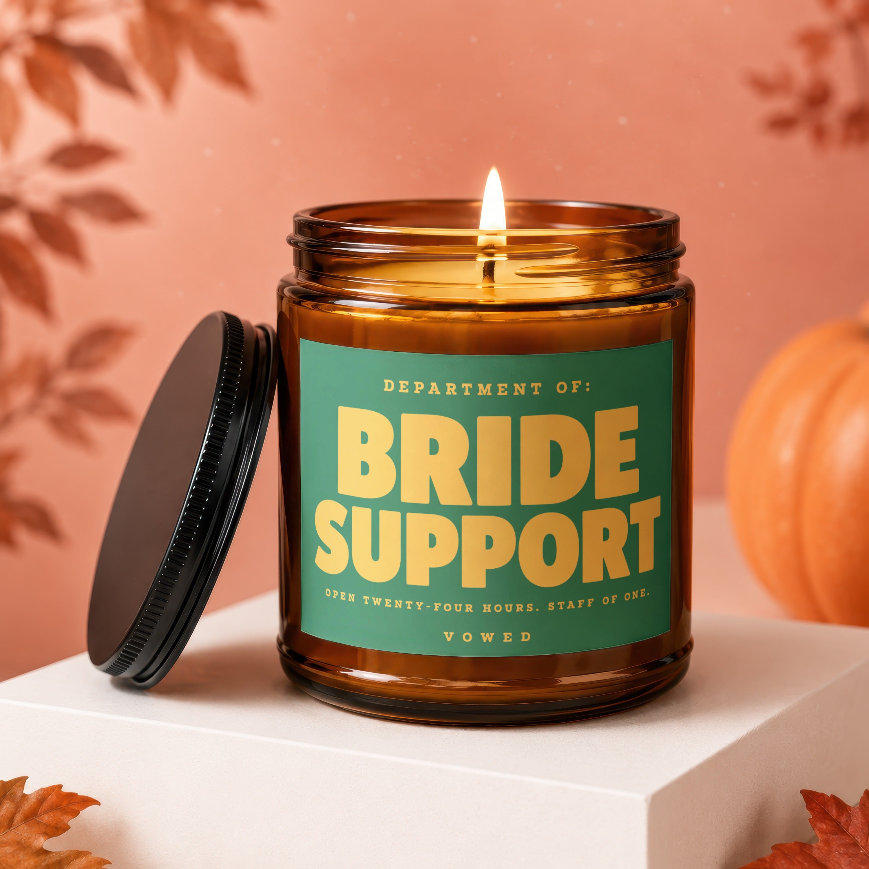 Amber glass candle with green label reading "Department of: Bride Support".