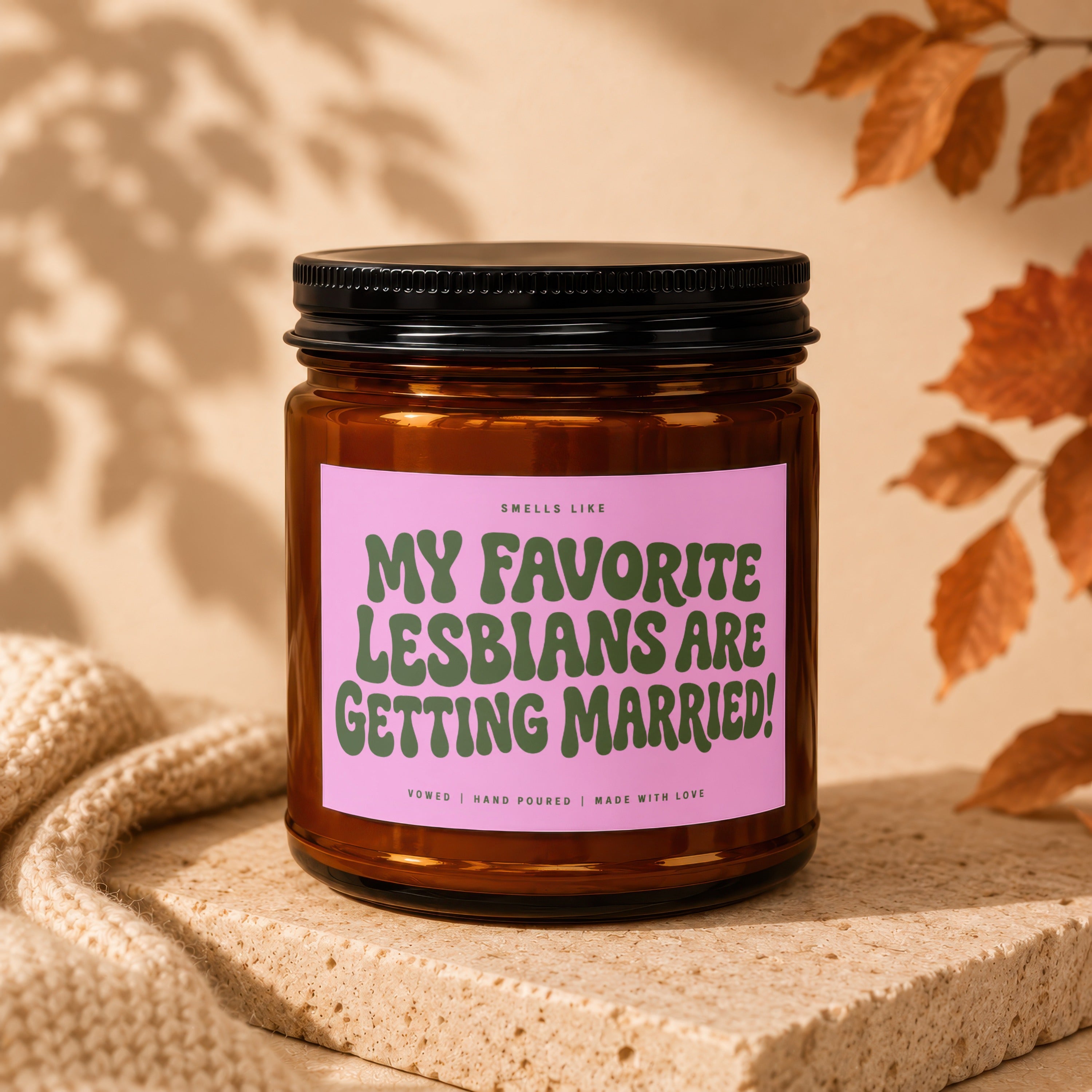 Amber jar candle with a pink label that reads "My Favorite Lesbians Are Getting Married!".