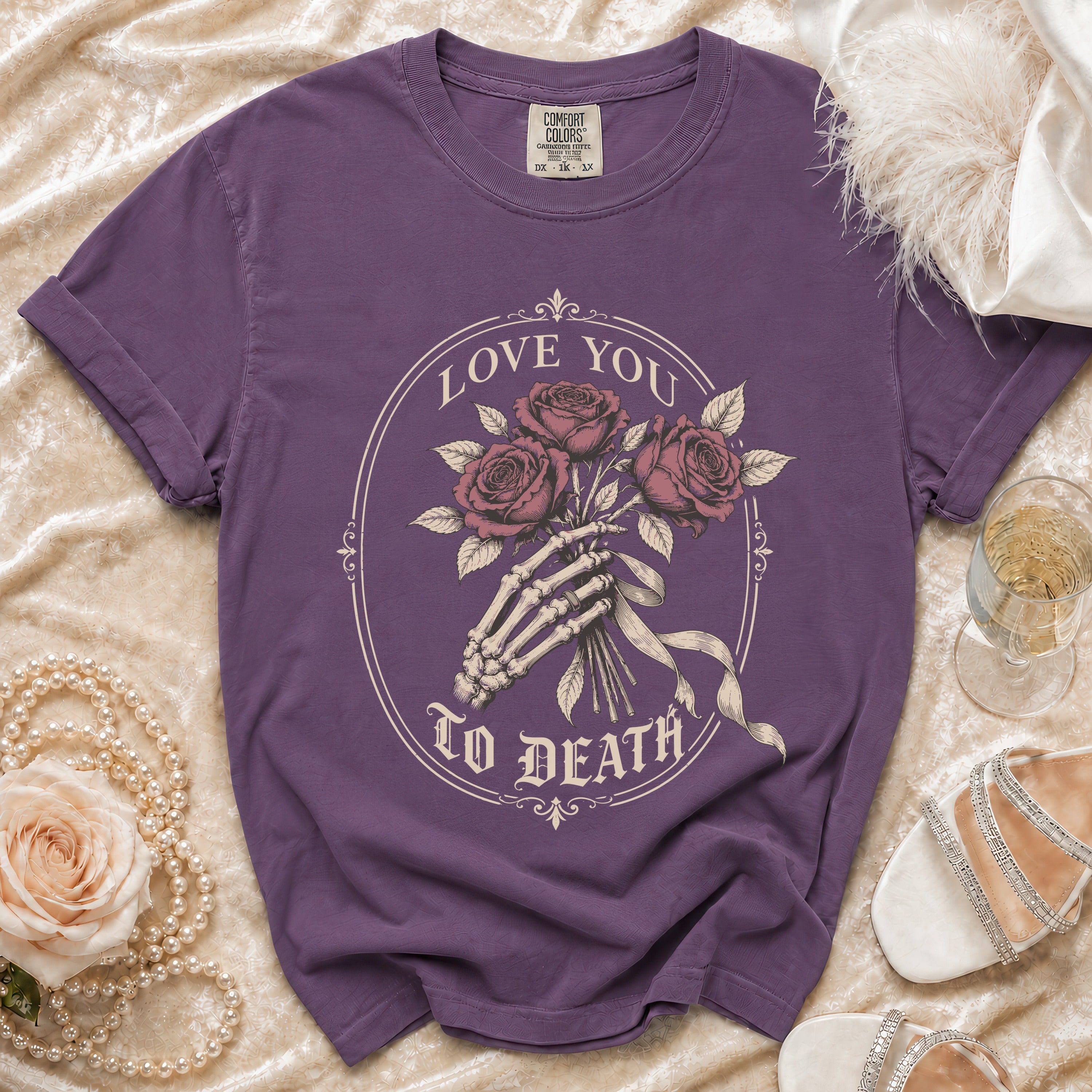 Purple t-shirt with skeleton hand holding roses and text "Love You To Death".