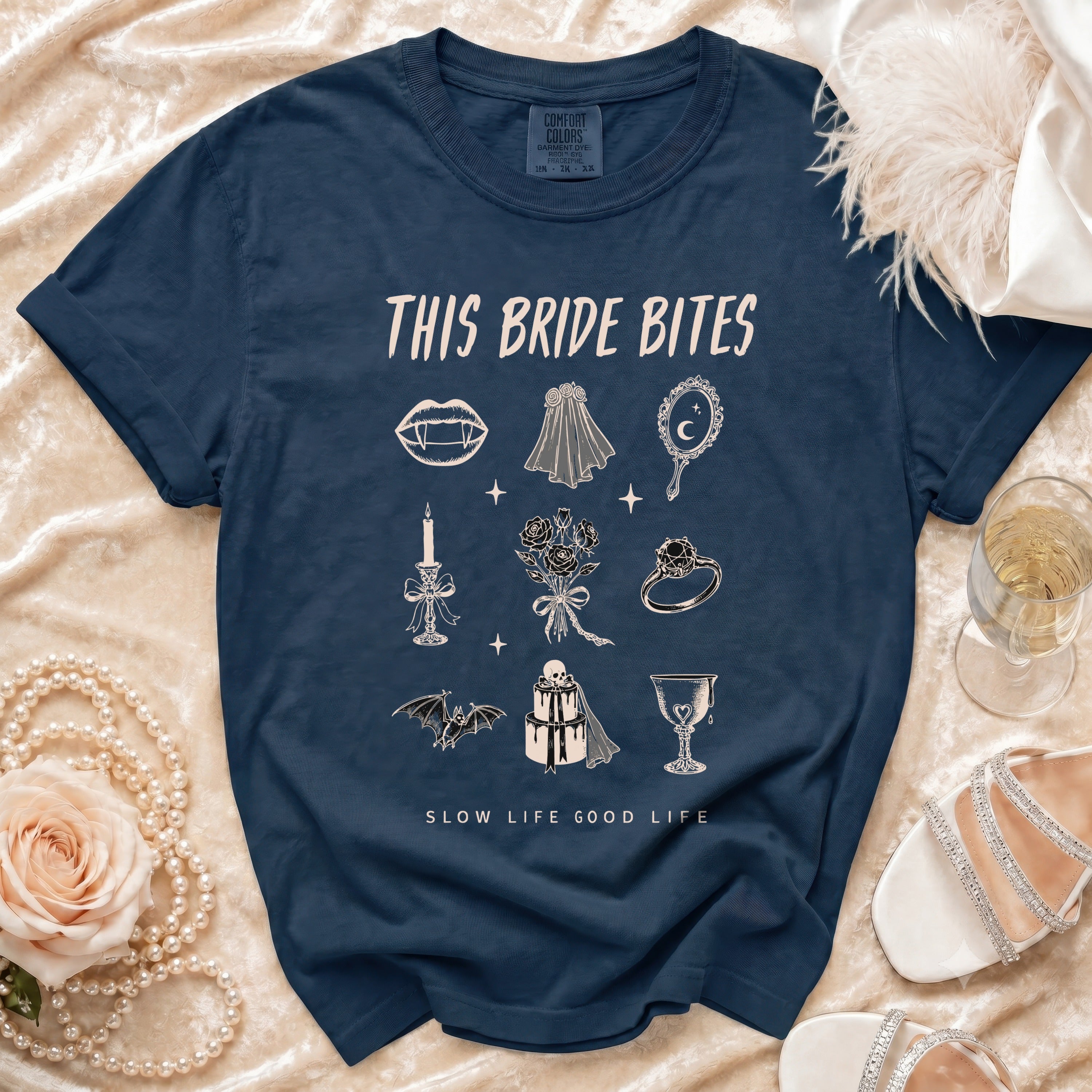 Dark blue t-shirt with "This Bride Bites" text and gothic wedding illustrations.