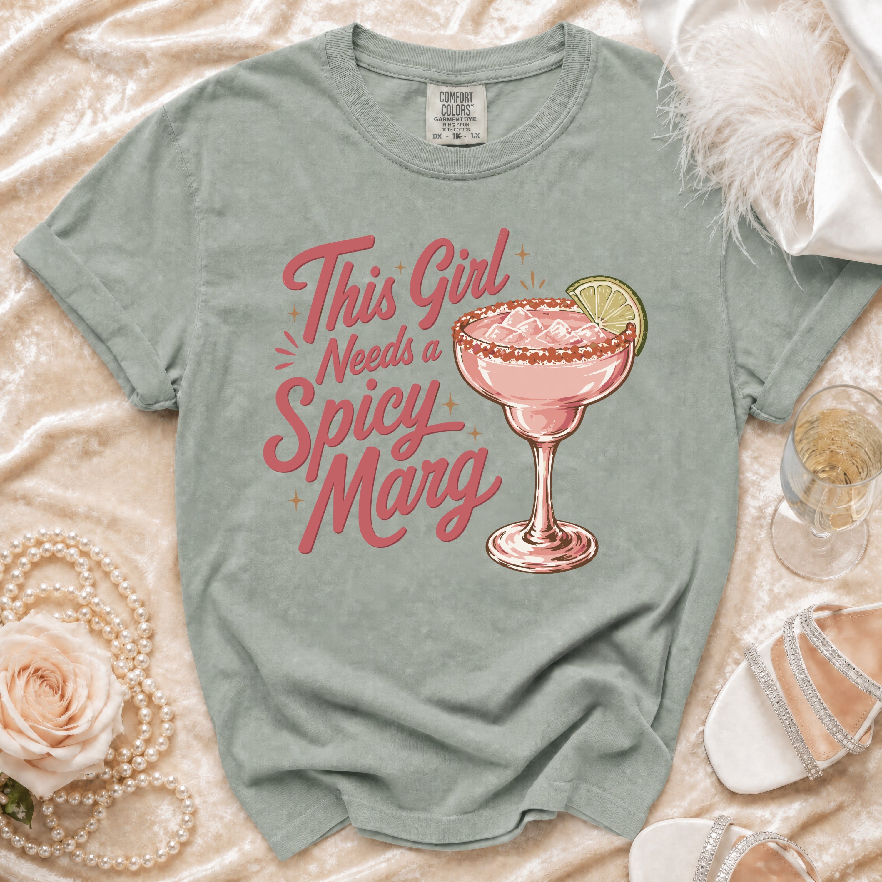 Light green t-shirt with "This Girl Needs a Spicy Marg" and margarita graphic.