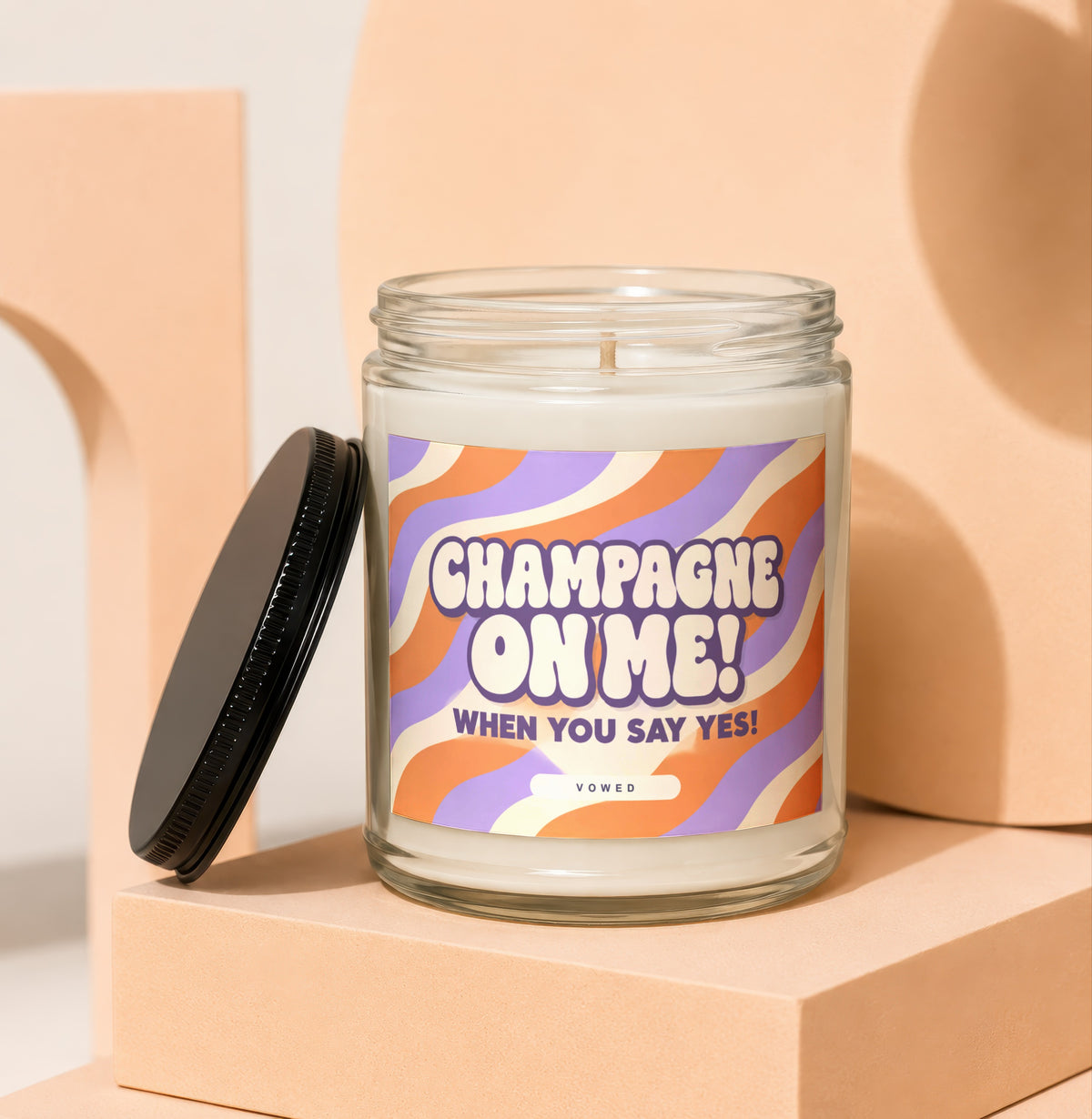 Glass candle with "Champagne On Me! When You Say Yes!" text on wavy label.