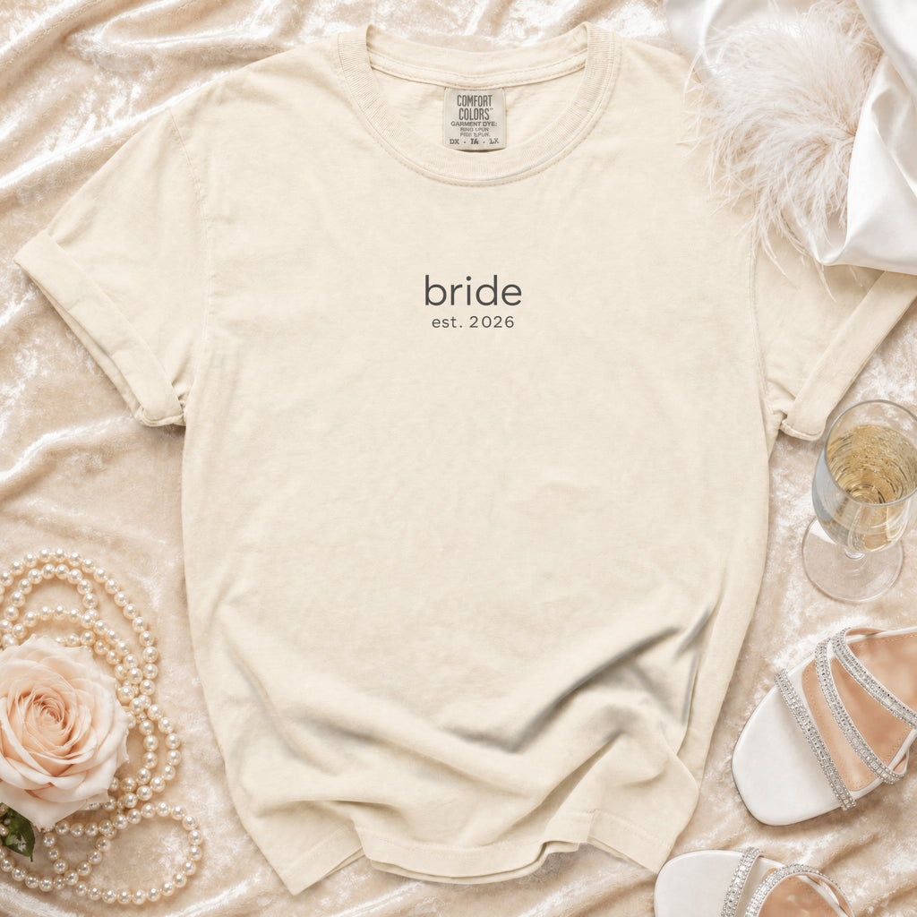 Cream "bride est. 2026" t-shirt with pearls, rose, and shoes.