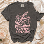 Dark grey t-shirt with pink text "Maid of Honor Because Therapy is Expensive" and champagne graphic.