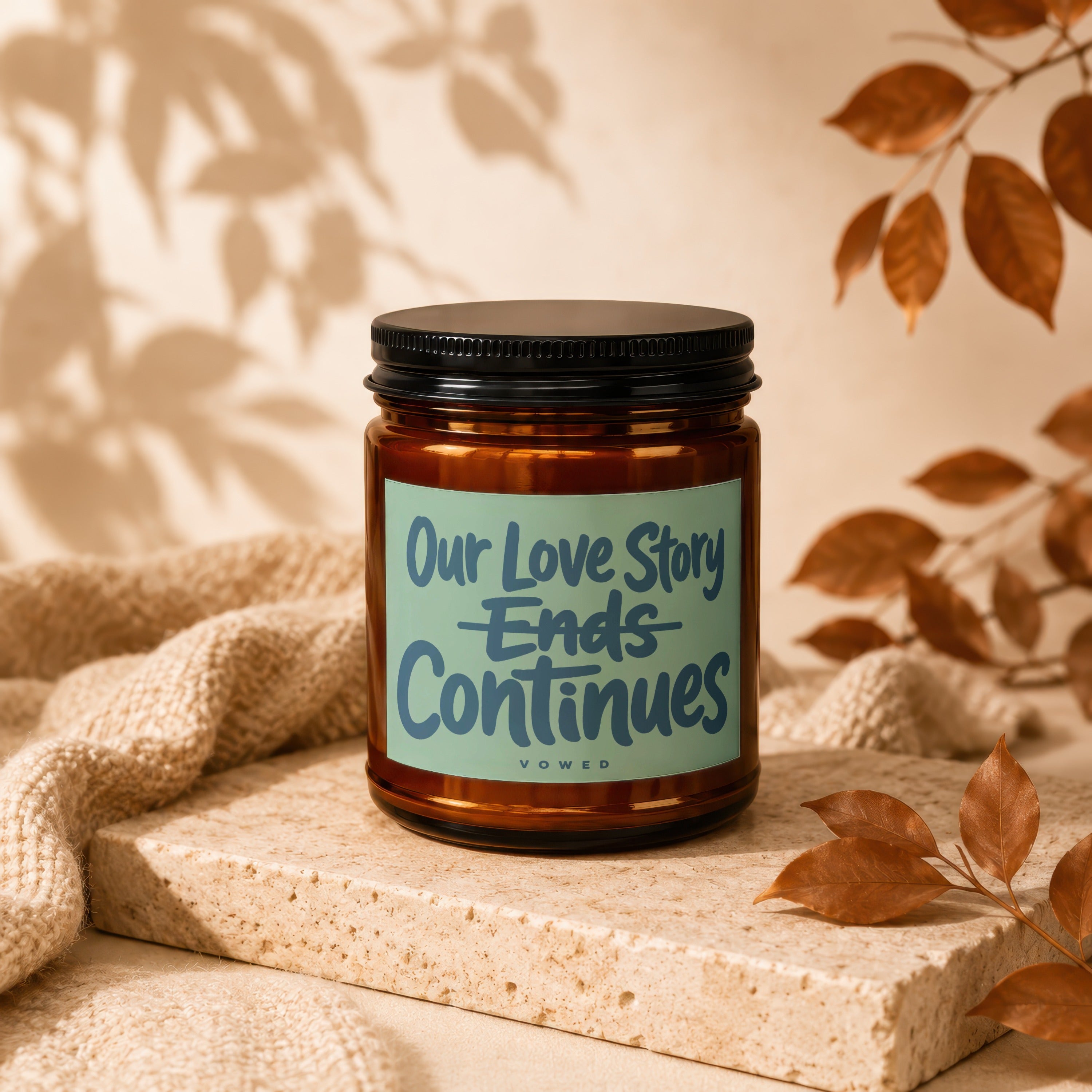 Amber candle with "Our Love Story Ends Continues" text, "vowed" below.
