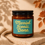 Amber glass candle with teal label reading "Married. Iconic. Done. VOWED."
