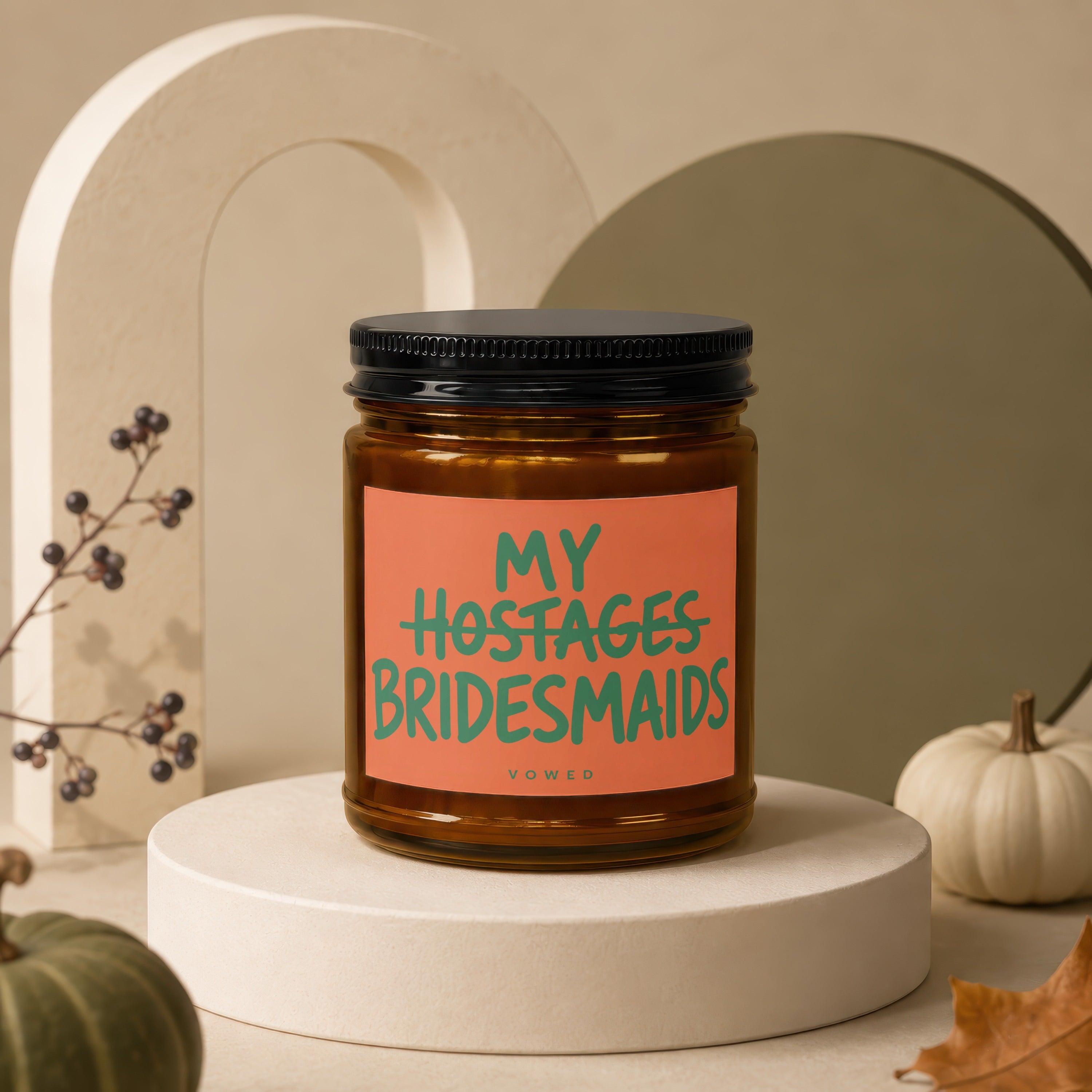 Amber jar candle with orange label reading "MY HOSTAGES BRIDESMAIDS" and "VOWED".