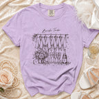Lavender t-shirt with "Bride Tribe" graphic showing robes, flowers, champagne, and accessories.