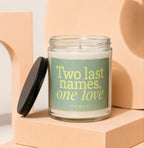 Glass candle with light green label reading "Two last names, one love".
