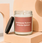 Glass candle with pink label reading "Bachelorette Weekend: Behavior Optional."