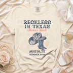 T-shirt with "Reckless in Texas Olivia's Bach Austin, TX Summer 2026" graphic.