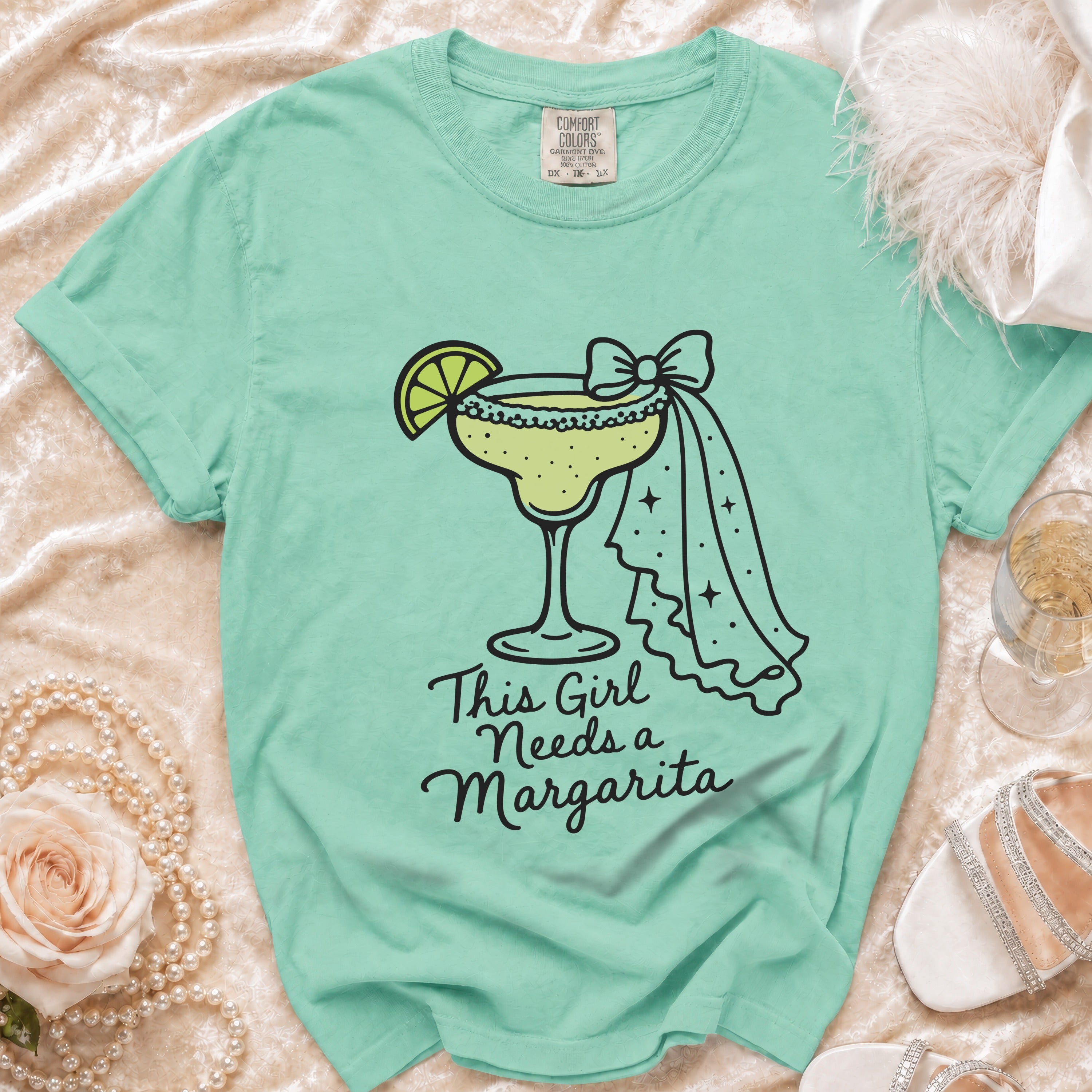Aqua t-shirt with a margarita graphic and text that says "This Girl Needs a Margarita."
