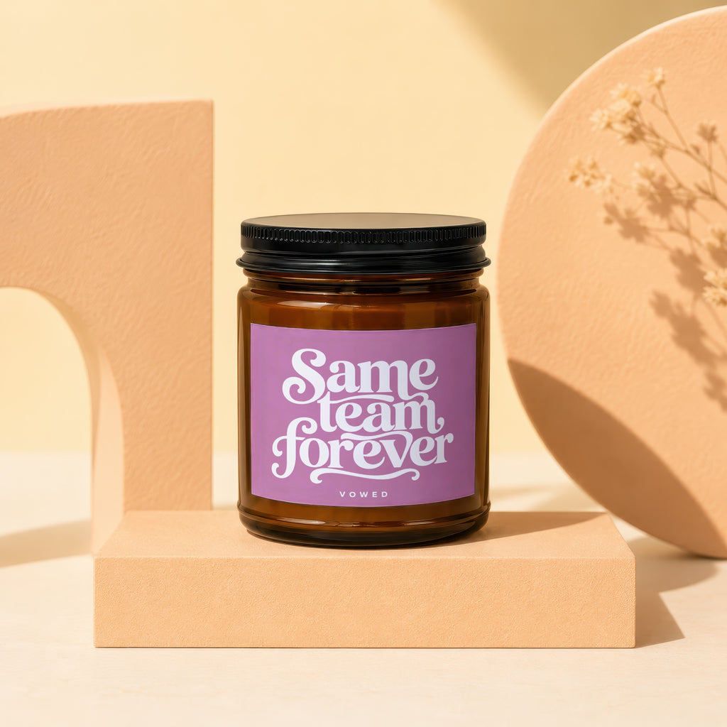 Amber jar candle with purple label reading "Same team forever" and "VOWED."