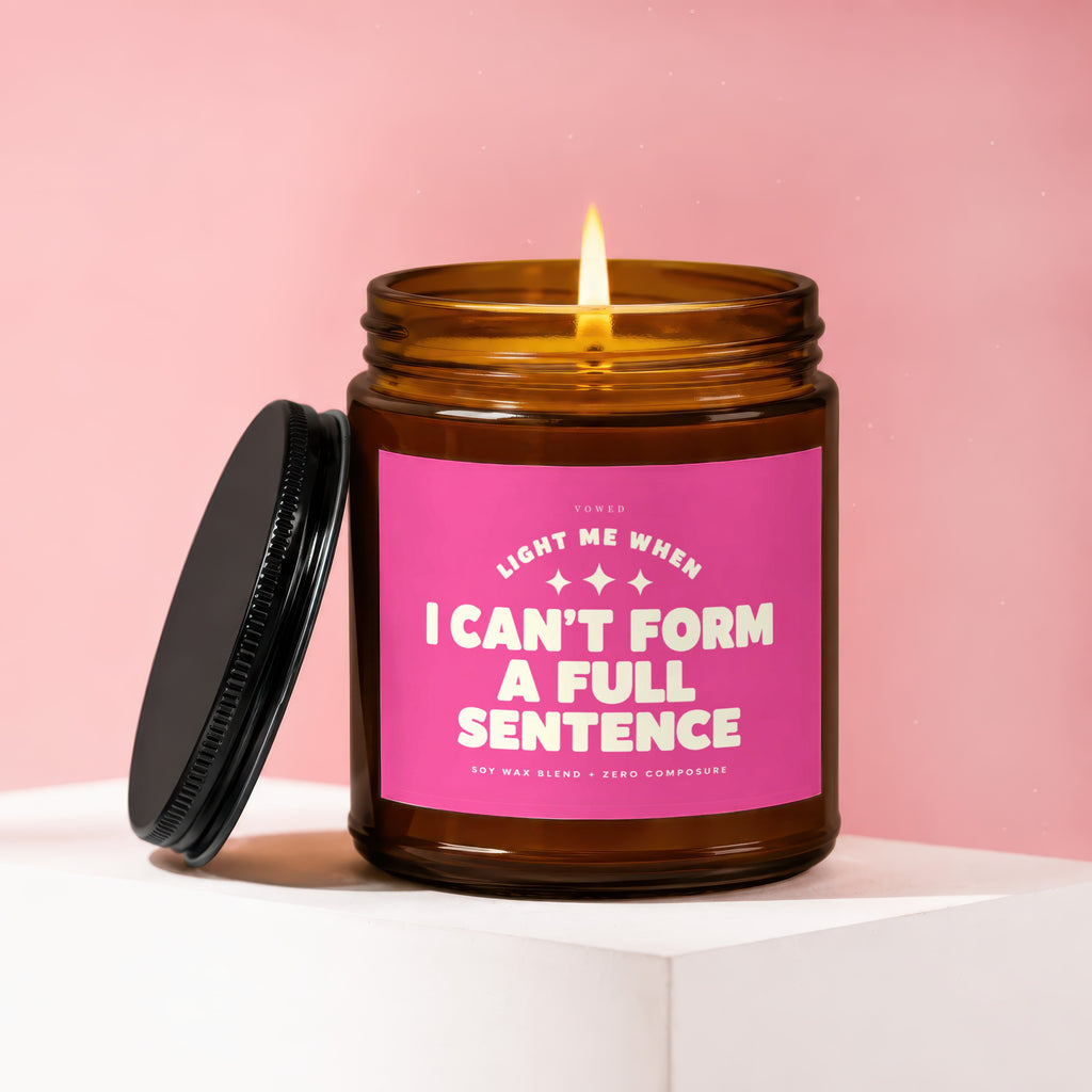 Brown glass candle with pink label reading "I CAN'T FORM A FULL SENTENCE"